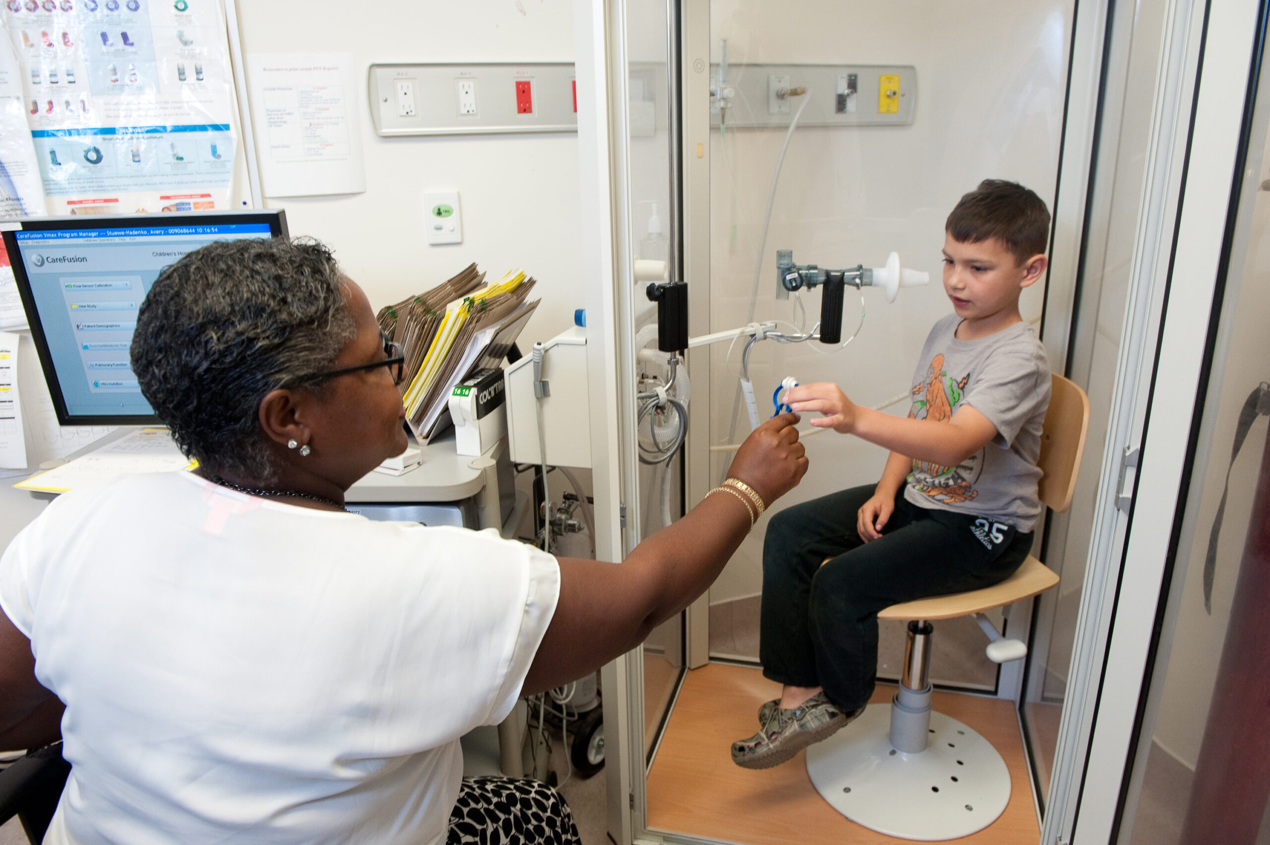 Un jeune garçon effectue un test pulmonaire avec l'aide d'une femme médecin.